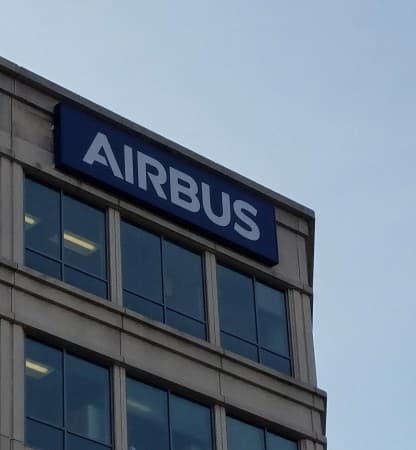 The Airbus wordmark on a navy sign mounted at the corner of an office building.
