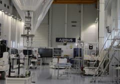 Inside an Airbus hangar, testing equipment set up on the workshop floor beneath the Airbus sign.