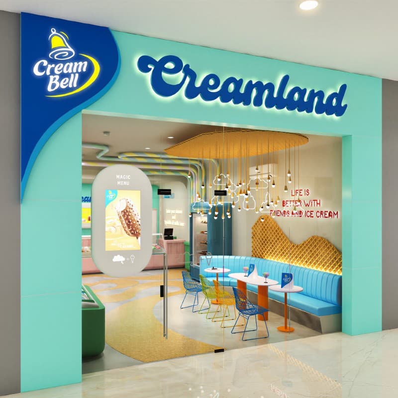 A visualisation of the Creamland shopfront, the Cream Bell logo and lockup lit above the entrance.