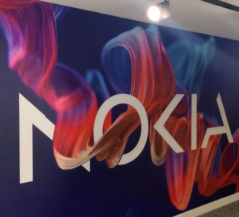 An abstract red and blue ribbon graphic behind the Nokia wordmark on a reception wall.