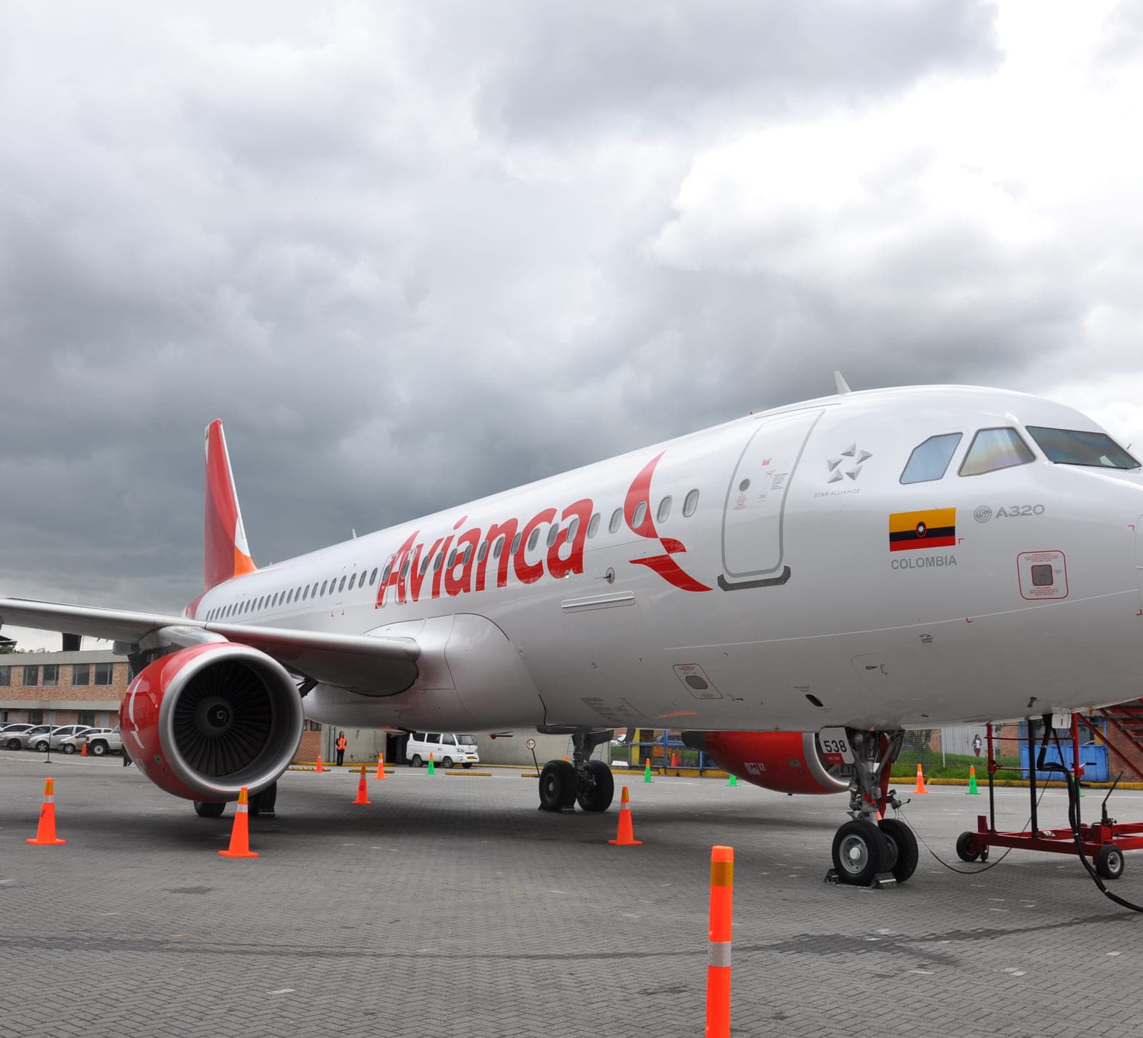 An Avianca aircraft on the apron in the new livery, the wordmark and bird symbol along its forward fuselage.