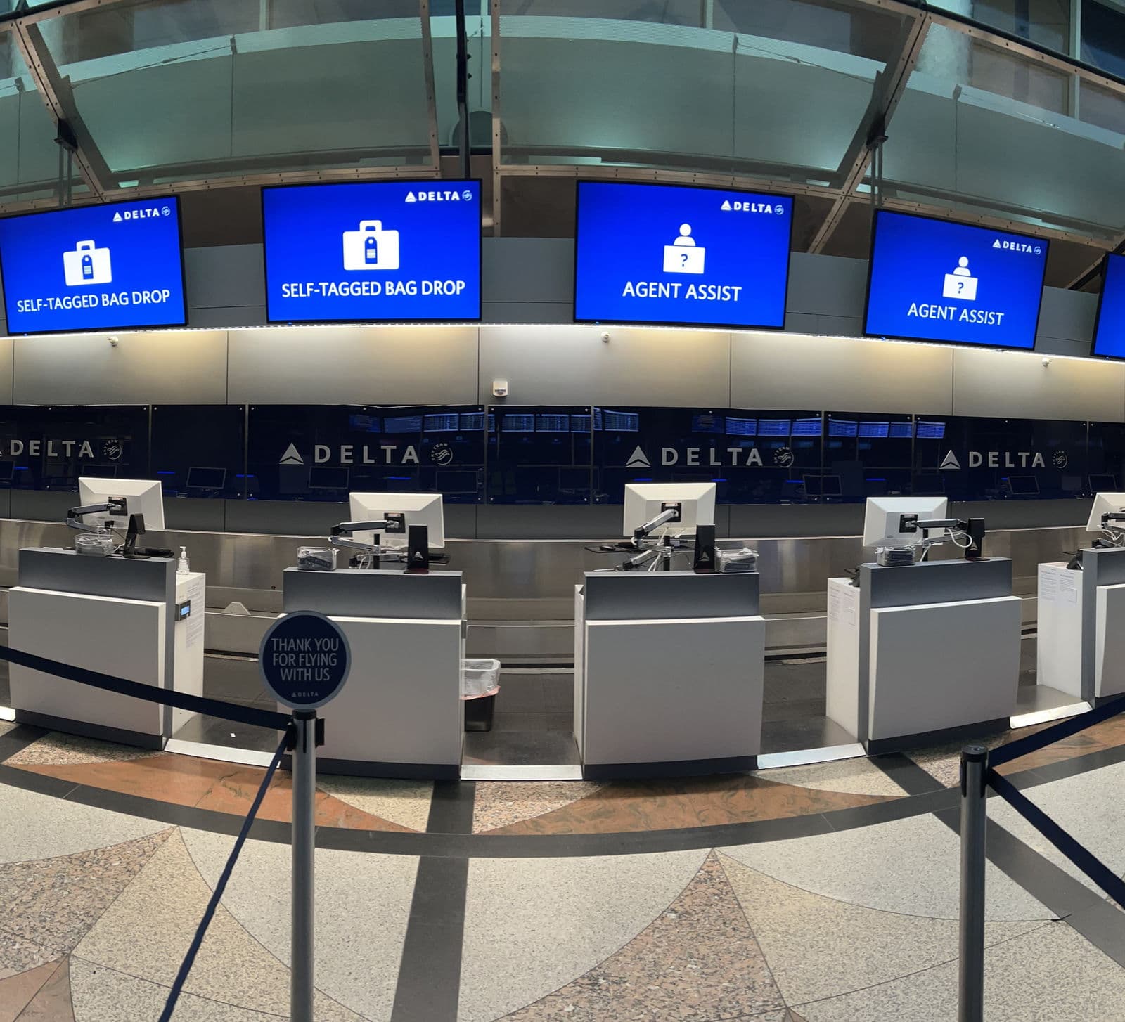 Delta's ticketing hall at Denver, bag drop and agent assist screens ranged along the counter.