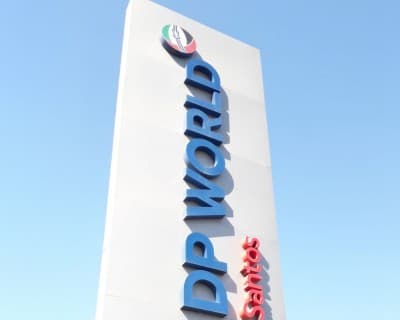 A DP World Santos entrance monument sign against a clear sky.