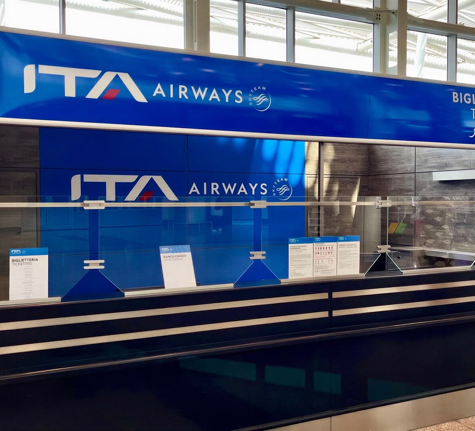 The rebranded ITA Airways ticketing desk, with new signage and branded partitions in place.