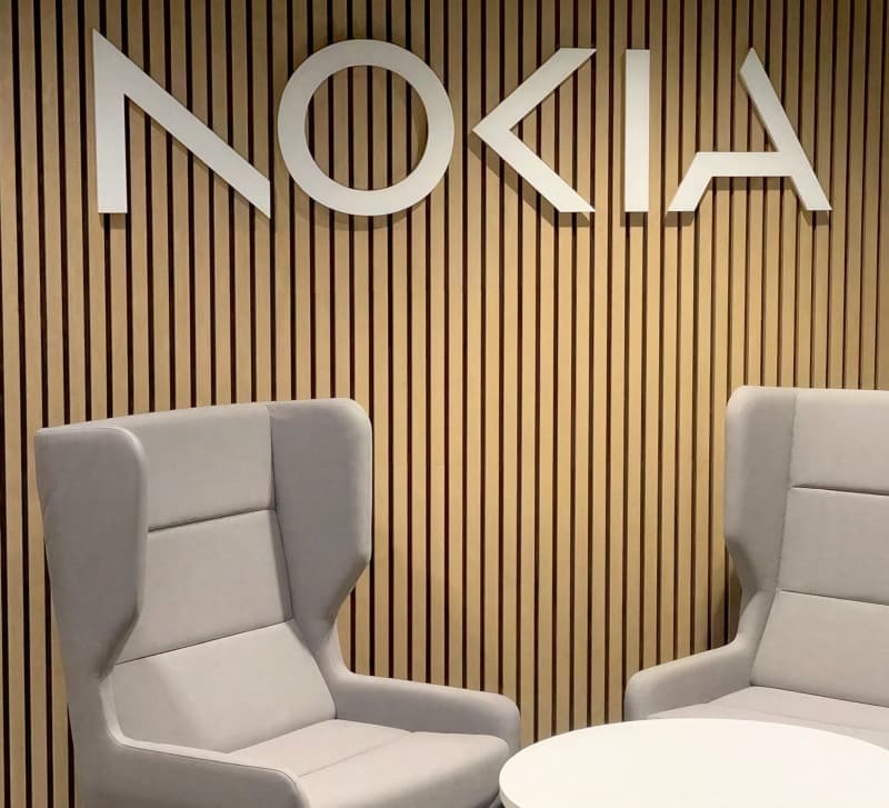 The Nokia wordmark mounted on a wood-slat wall behind two lounge chairs in a reception area.