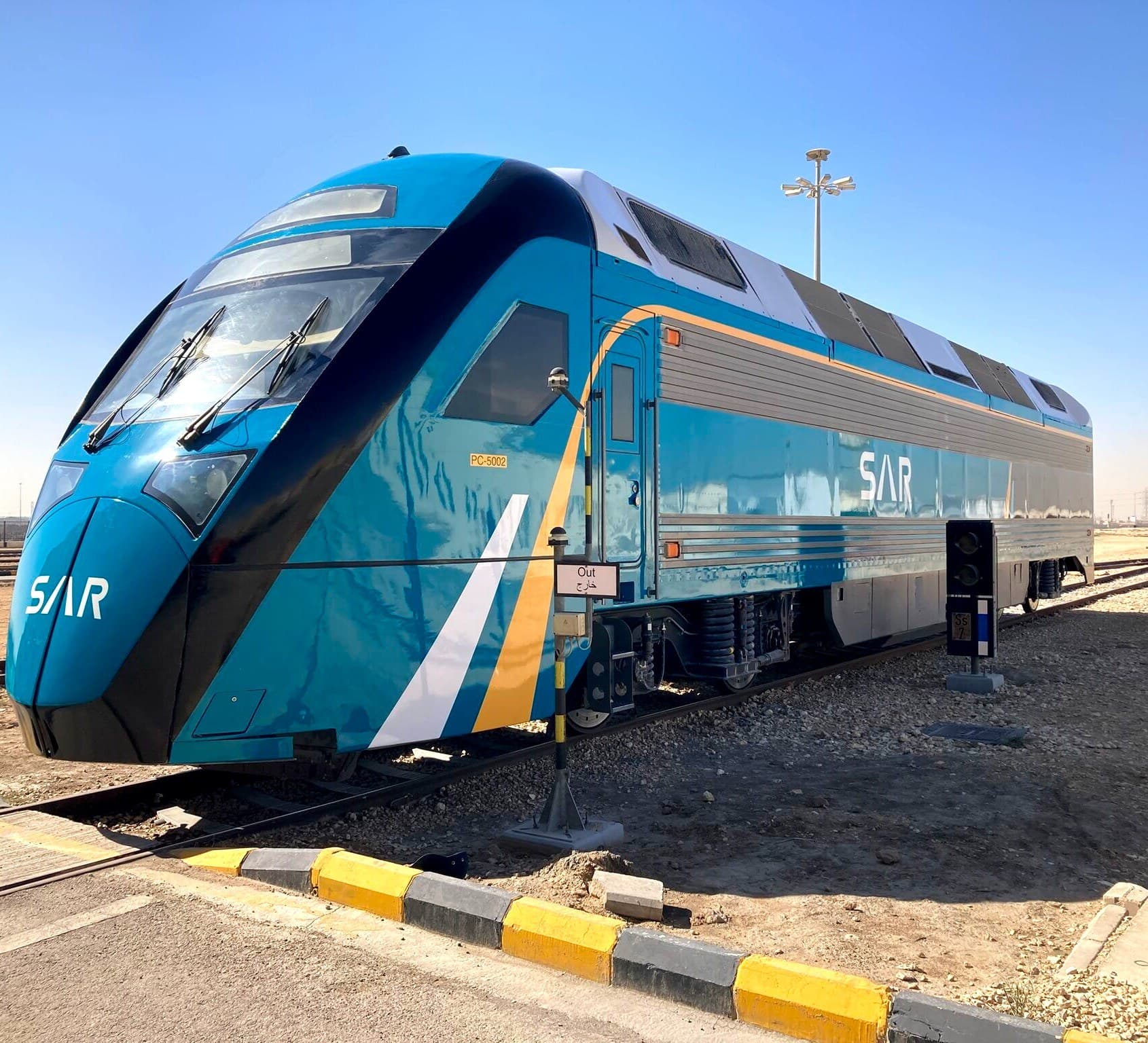 The SAR power car trackside in the desert, its triple-layer livery catching the sun.