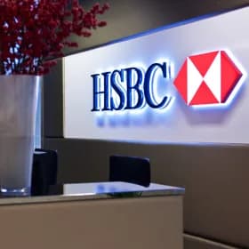 An HSBC hexagon sign lit above a reception counter