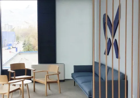 A meeting room screened by timber slats, with the client's mark on the glass partition
