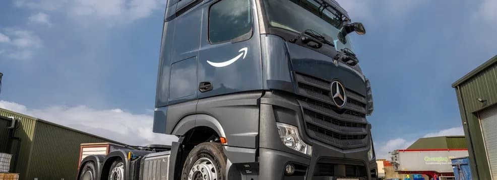 The Amazon smile logo on the cab door of a liveried HGV tractor unit.