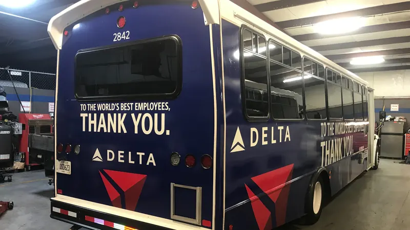 A Delta-liveried transit bus, branded with a 'To the world's best employees, thank you' message.