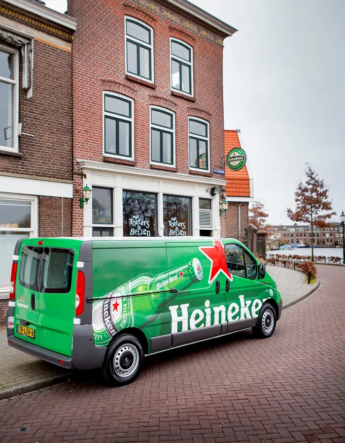 A Heineken-branded delivery van parked on a European street.