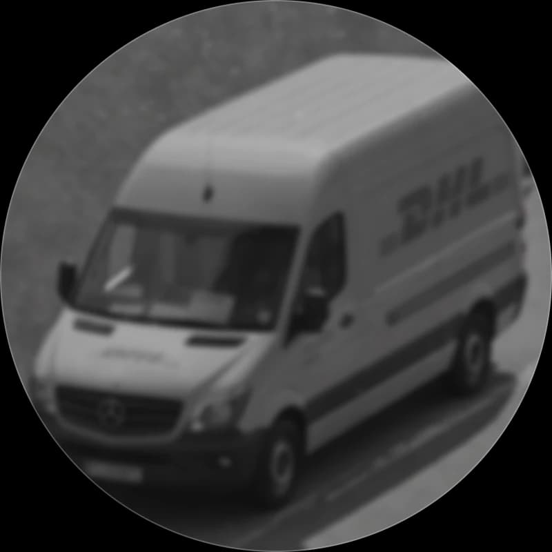A branded DHL delivery van on the road, seen from above