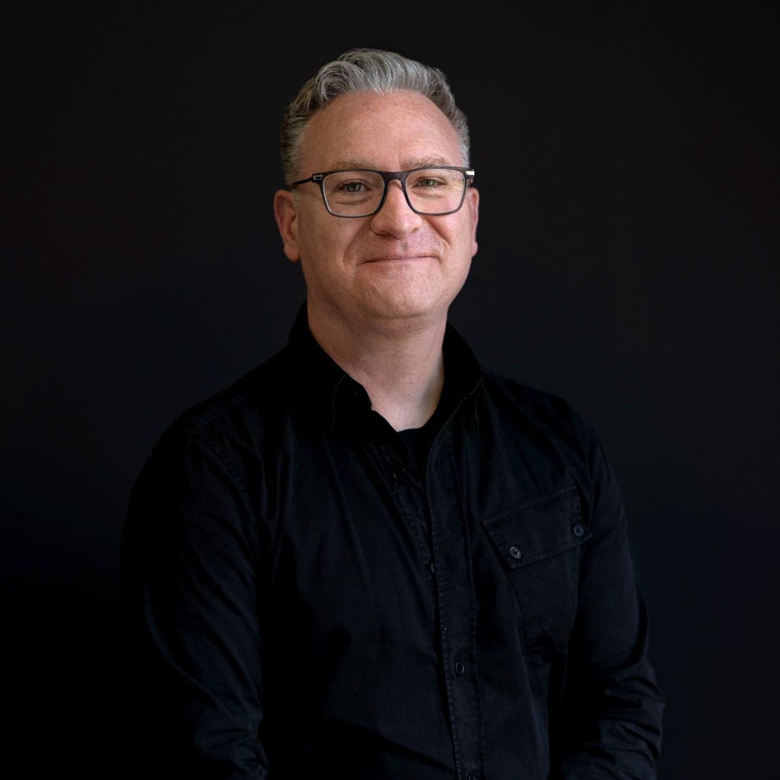 Portrait of Ross Haxton against a dark background