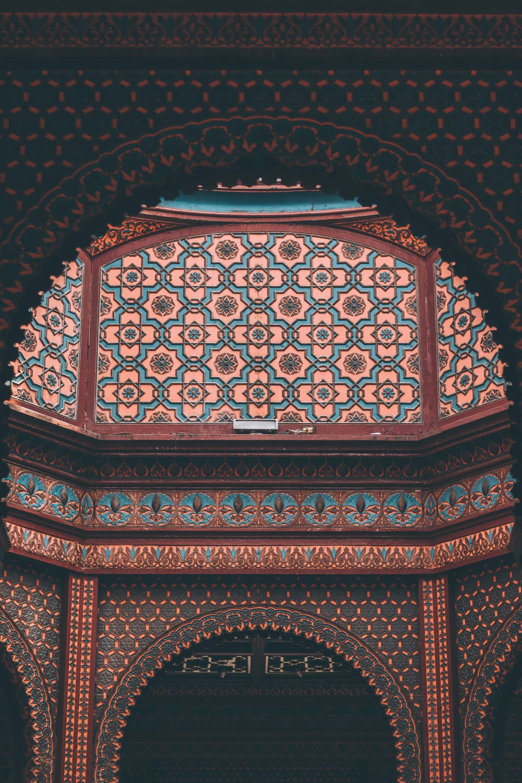 Intricately tiled and painted interior arch in orange and turquoise