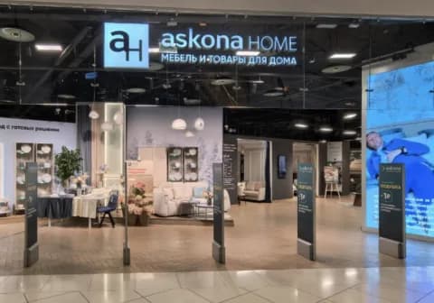 An askona HOME store entrance inside a shopping centre, under an illuminated fascia sign