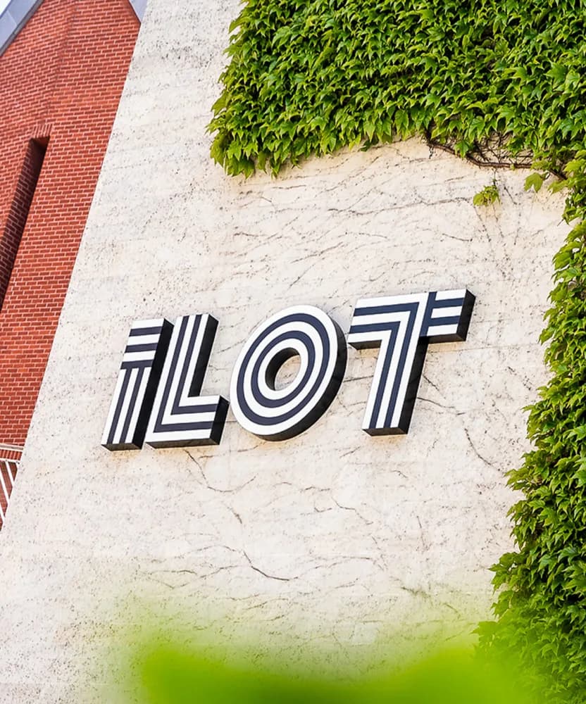 The ILOT wall sign mounted on a planted facade