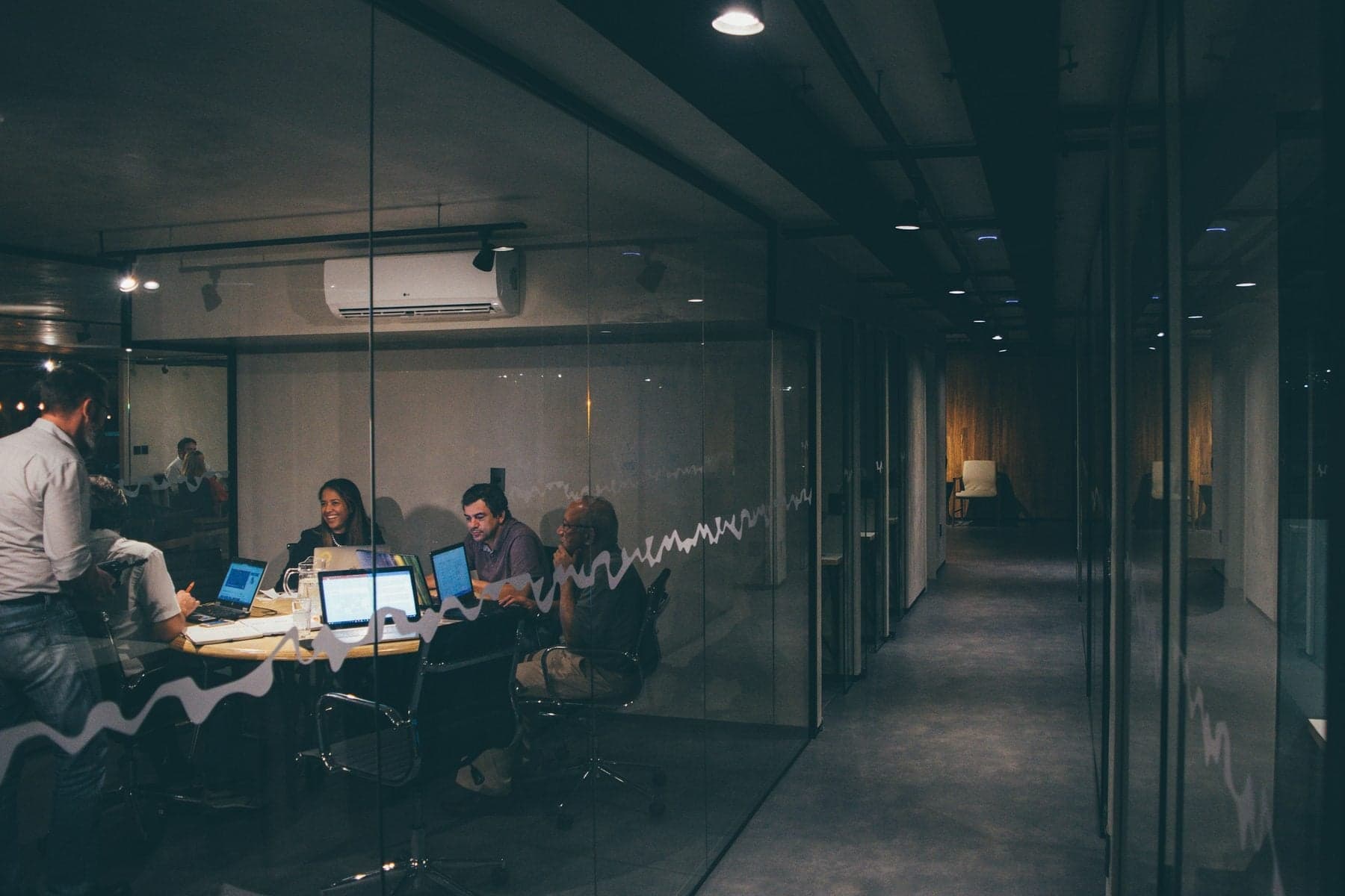 A brand team at work in a glass-walled meeting room